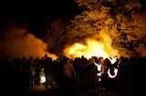 Crowds of people gathered around a blazing bonfire celebrating Bonfire Night or Guy Fawkes on the 5th November