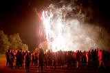 Crowd of people gathered in a field watching a colorful firework display on Bonfire Night or Guy Fawkes on 5th November