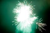 Bright fiery explosion of green fireworks in a dark night sky to celebrate a festival of special event