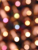 Background texture of festive party lights in a colorful bokeh evenly spaced in rows through the frame for Christmas, New Year or party themes