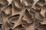 Christmas background of assorted cookie cutters arranged on a wooden table viewed high angle full frame