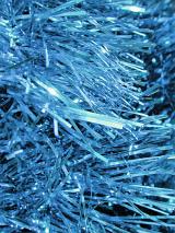 Festive sparkling metallic blue tinsel in a full frame Christmas background, close up view