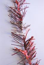 Strand of festive red Christmas tinsel to decorate the tree or Xmas table lying on a grey background