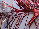 Bicolor red and silver Christmas tinsel for a festive party decoration in a close up view over grey