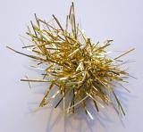 Metallic gold Christmas tinsel with sparkling strands in a small ball over a grey studio background, closeup view