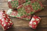 Pile of colourful wrapped Christmas presents or gifts on a wooden floor ready for Xmas morning