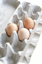 Three fresh hens eggs in a moulded cardboard carton used for retail packaging
