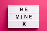 Sentimental Be Mine X Valentines message with bold text on a small light box over a bright pink background