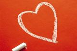a love heart shape drawn in white chalk on a red background