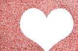 Blank white heart with copyspace for your greeting to a sweetheart or loved one in a textured red glitter background symbolic of love and romance for Valentines Day