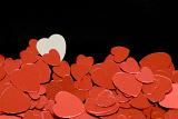 a background or bottom border of red metallic heart shapes on a black backdrop