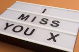 Sentimental message - I Miss You with an X for a kiss in simple uppercase black lettering on a light box or display board