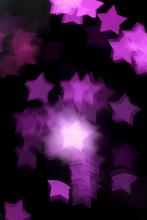 an abstract background image of defocused pink coloured bokeh light shapes