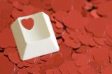 a computer key with a heart symbol on a backdrop of red heart shapes, concept of computer or online dating