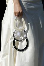 a wedding bride carrying three lucky silver horse shoes