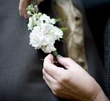 pinning a buttonhole into place before a wedding
