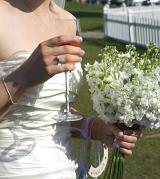 a champagne wedding reception with bride with glass, lucky charms and a bouquet of stocks
