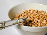 Close up view looking down the handle of the spoon into a plate of breakfast cereal for a healthy start to the day