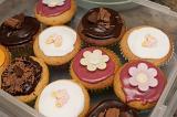 Decorated mini cupcakes with assorted pink white and chocolate icing topped with flowers and butterflies for a tea or birthday party