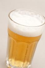 Cold beer with a good frothy head served in a glass, high angle close up view