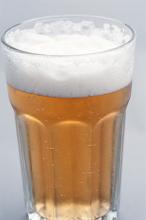 Glass of lager, draft or beer with effervescent bubbles and a frothy head, close up view