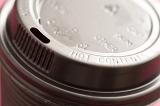 Detail of the lid of a plastic takeaway coffee cup viewed at an angle to enhance the text - hot contents - on the rim