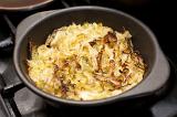 Baked finely sliced fresh cabbage in an oven dish ready for serving as an accompaniment to dinner