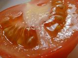 Macro of a sliced fresh tomato viewed at an oblique angle showing the juicy texture of the pulp