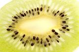 Section of a fresh kiwifruit with seeds surrounding the inner core, close-up