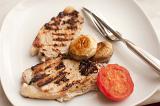 Two delicious lean healthy grilled pork chops served with tomato and mushrooms, high angle view