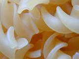 Close up background texture of cooked plain spiral pasta in the distinctive twisted form of Italian fussili