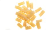 Dried Italian rigatoni pasta with its distinctive slightly curved shape and ridge texture scattered on a white surface viewed from above with copyspace