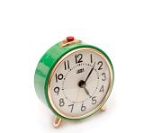 Retro green alarm clock with a round dial and Arabic numerals and a small red button at the top to deactivate the ring on a white background