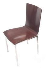 Modern dining chair with a molded seat and tubular metal legs, angled side view isolated on white