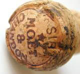 Close up of the top of a Moet and Chandon champagne cork showing the labeling and vintage