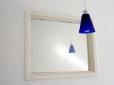 Modern Ceiling Lamp with Contemporary Blue Shade Reflected in White Framed Mirror as part of Home Decor