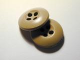 Two classic simple brown buttons for garment repair and needlework or tailoring on a grey background