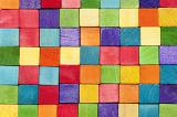 Background pattern of colorful toy wooden blocks or cubes in the colors of the rainbow neatly arranged in rows
