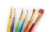 Selection of colorful paint brushes for kids with translucent plastic handles and assorted tips on a white background
