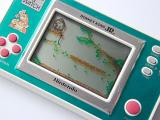 Kids video game and watch illuminated screen with a monkey in a tree and colorful plastic dials