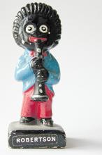 Old vintage black Golly Wog figurine of a musician playing a clarinet, now considered racist and out of favor