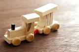 Kids wooden toy train made of pine with an engine pulling a single carriage on a wooden table, high angle view