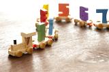 Wooden educational toy numbers train with an engine drawing a winding line of coaches with colorful numerals to teach basic counting to kids