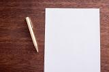 Starting with a clean slate concept showing a blank empty page of white paper lying beside a pen on a desk