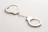Pair of unlocked metal handcuffs lying diagonally on white in a conceptual image of law and order, captivity and freedom