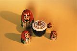 Set of nesting Russian Babushka dolls with the bottom halves stacked and heads surrounding them on yellow
