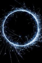 blue circle of catherine wheel sparks on a dark background