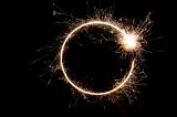 a circular loop of sparkling light with a bright dot of sparks