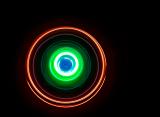 swirls of light in orange and green glowing concentric circles on a black backdrop
