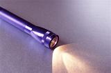 a purple coloured torch or flashlight with light shining out of the front